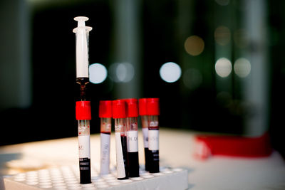 Close-up of blood sample in tubes with syringe on tray at laboratory