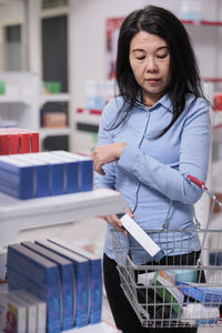 Portrait of smiling young woman standing in library