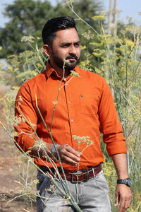 Man with umbrella standing on field