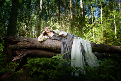 Rear view of woman standing in forest