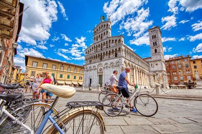 People riding bicycle on building in city