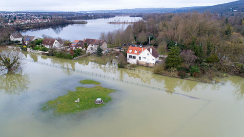 High angle view of houses by trees against sky