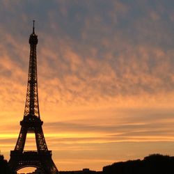 Low angle view of tower against sky at sunset