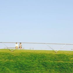 Grassy field against clear sky