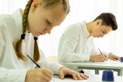 Teenage boy and girl giving educational exam