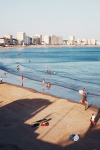 People on beach against clear sky