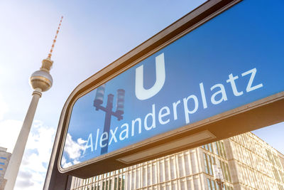 Low angle view of sign board against blue sky