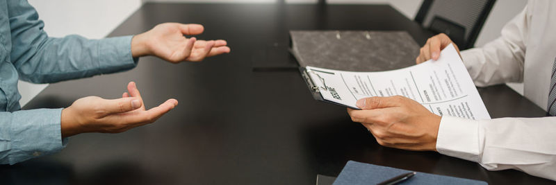 Midsection of businessman giving paper currency