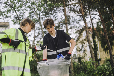 Boys collecting plastic in garbage bag