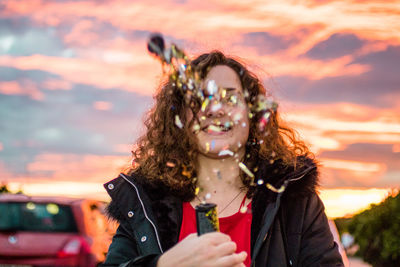 Portrait of smiling woman against sky during sunset