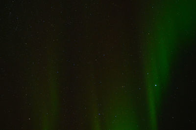 Defocused image of illuminated lights against sky at night