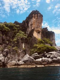 Rock formations by sea against sky