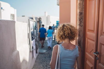 Rear view of woman standing against building