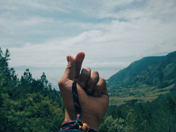 Midsection of person against mountains against sky