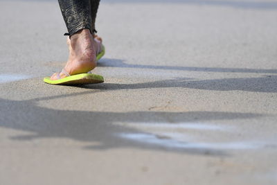 Low section of man walking on road