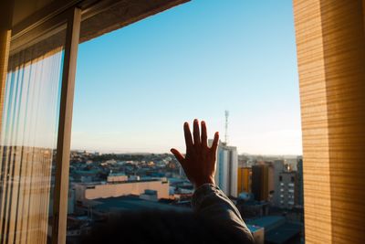 Close-up of hand looking through window