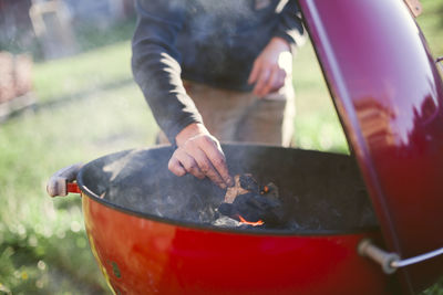 Hands lighting fire in barbecue