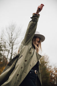 Low angle view of woman wearing hat against sky