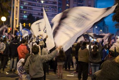 Protestors protesting in city at dusk