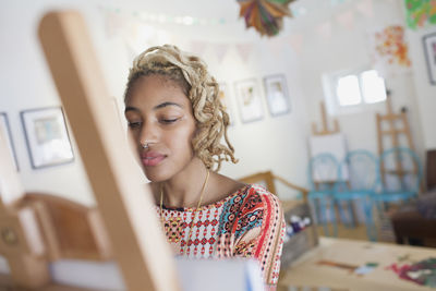 A young woman in front of an easel