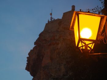 Low angle view of illuminated street light against sky at sunset