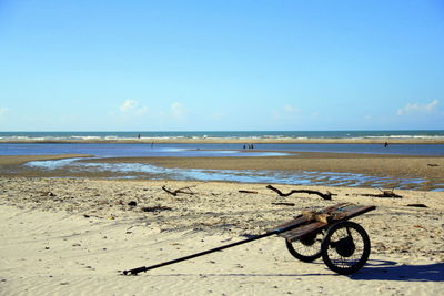 Bicycle on beach against sky