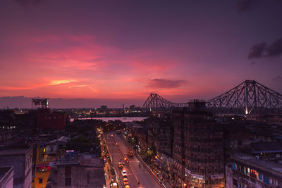 High angle view of illuminated city against sky at sunset