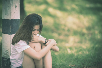 Full length of girl sitting on field