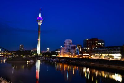 Illuminated buildings in city at waterfront