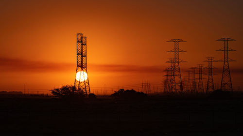 Low angle view of electricity pole during sunrise