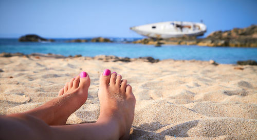 Low section of woman relaxing on beach