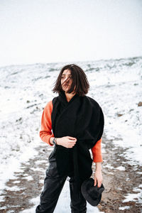 Woman standing on beach against clear sky during winter