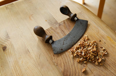 Vintage rocking knife and nuts on wooden board - chopping nuts for healthy dessert