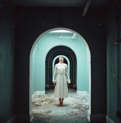 Rear view of woman standing against building