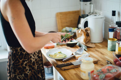 Midsection of woman preparing food at home