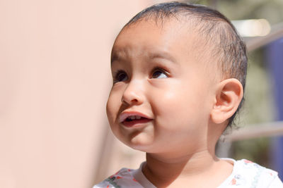 Close-up of cute baby girl looking away