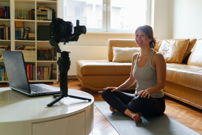 Woman sitting on sofa at home