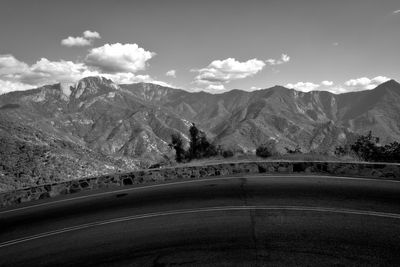 Road by mountains against sky