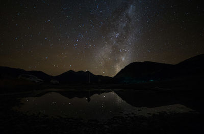 Scenic view of lake against mountains at night