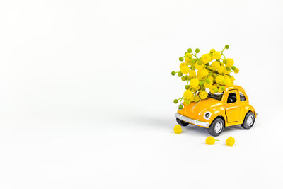 Close-up of yellow toy car against white background