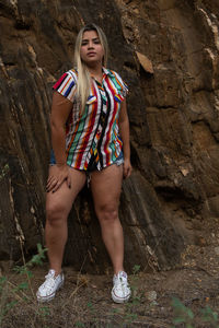 Portrait of young woman standing on rock