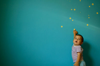 Baby girl against wall with stars