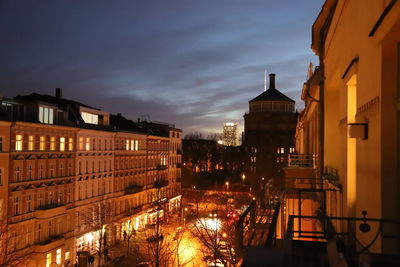 High angle view of illuminated street amidst buildings at night