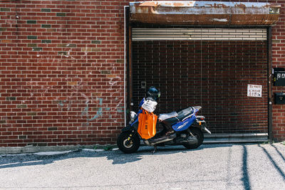 Motor scooter parked on street against building