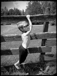 Full length of boy with arms raised in background