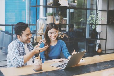 Young couple sitting on table at home
