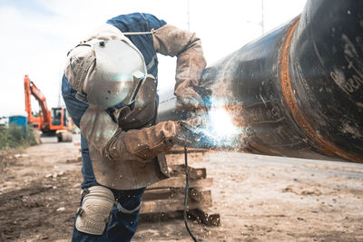 Man working on metal welding water pipe