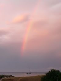 Scenic view of rainbow over sea against sky