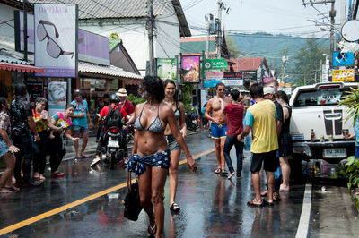 People walking on wet road in rainy season