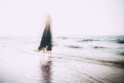 Full length of woman on beach against clear sky